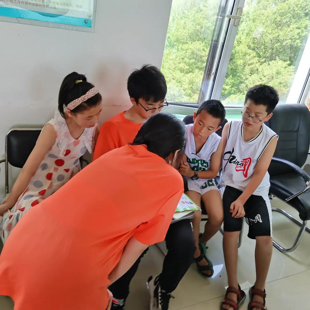 图为实践团成员给孩子讲解音标.jpg 图为实践团成员给孩子讲解音标.jpg