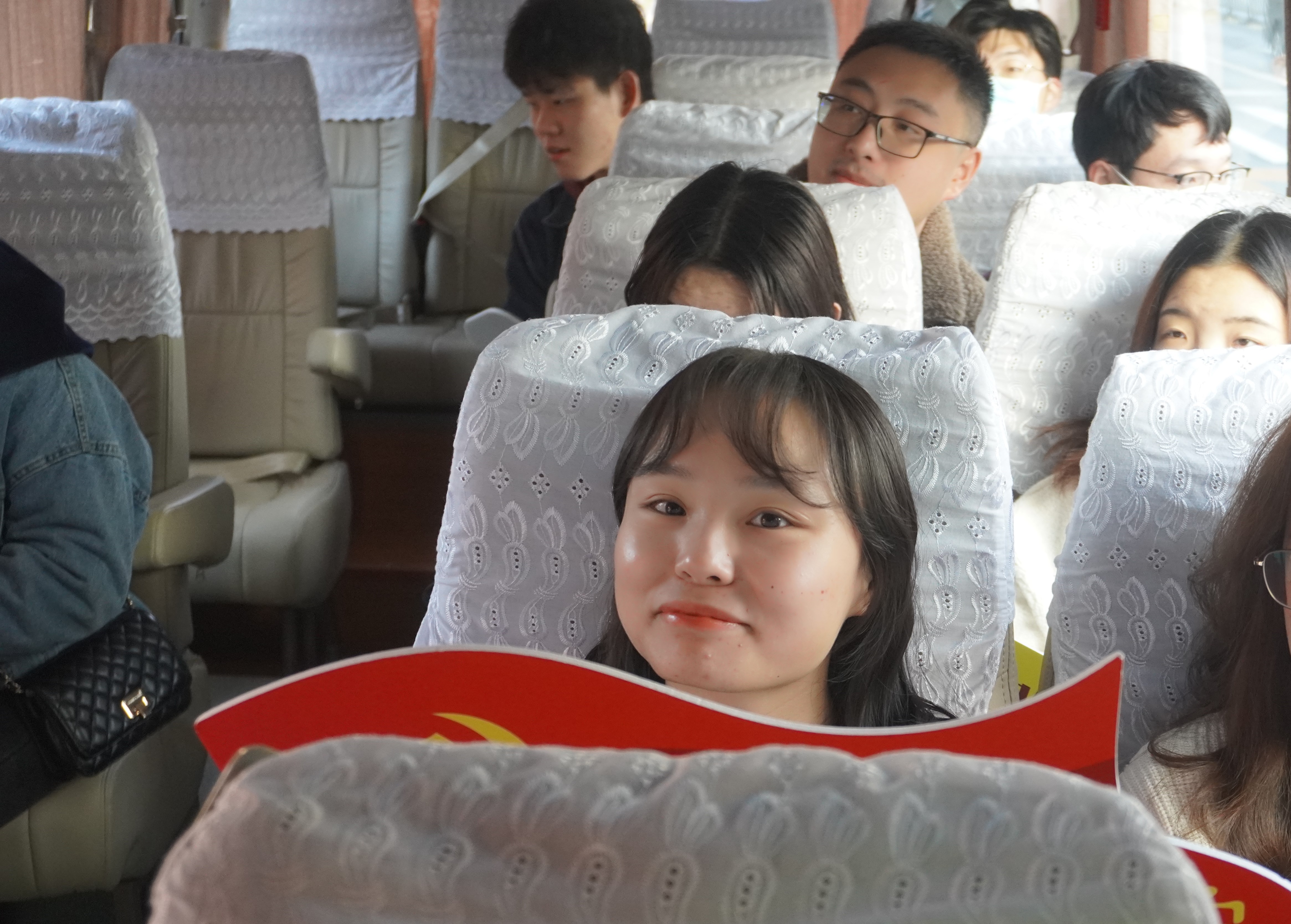 图为上财法学会党支部成员出发前乘坐大巴合影留念；暖冬的早晨天气颇好，支部成员都十分期待今天的红色法文化探寻之旅。