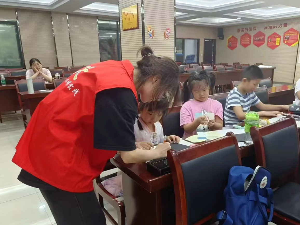 图为学生阙芸婕在江苏省无锡市锡山区春江花园党群服务中心参加爱心暑托班实践活动,协助班主任开展知识小讲堂、托管照顾等工作。
