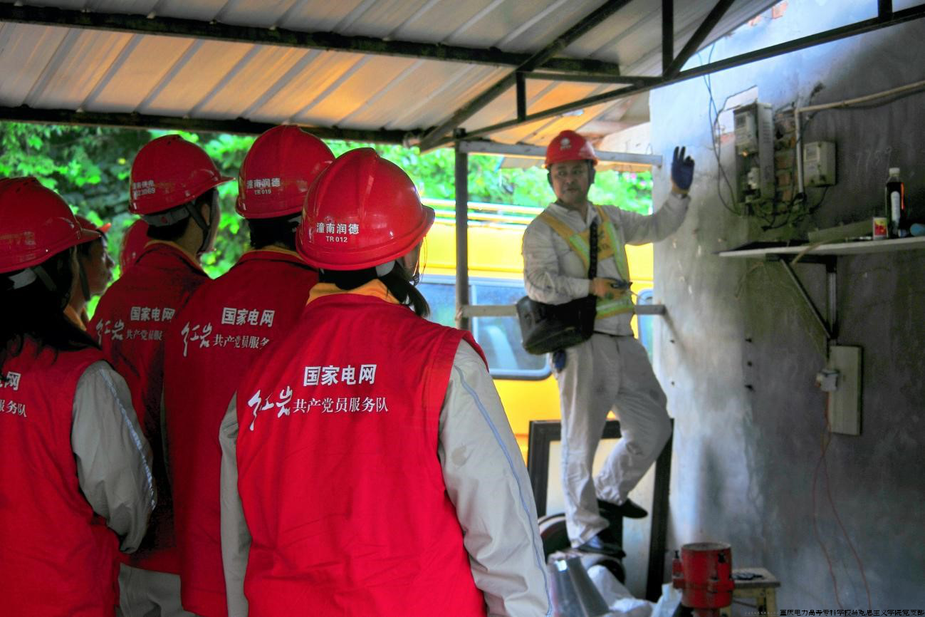 图为电力员工向传承团成员们介绍电表用法的场景.png
